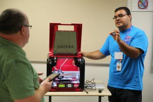 Penn Technology employee Brad Miller shows off a 3-D printing machine
