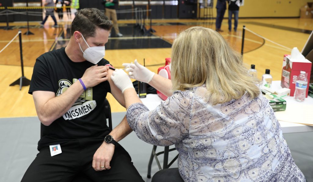 Meijer Clinical Pharmacy Specialist Amy Jennings administering vaccine to Penn Principal Sean Galiher