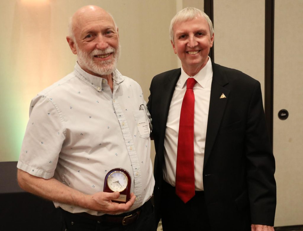 Dr. Jerry Thacker stands with PHM Retiree