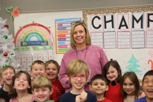 woman in pink sweatshirt with young students