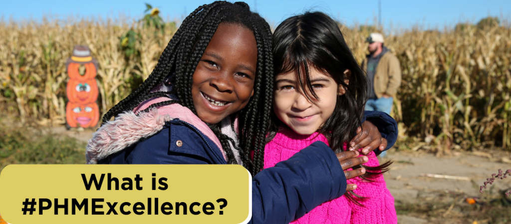 What is #PHMExcellence, two girls hugging in pumpkin field