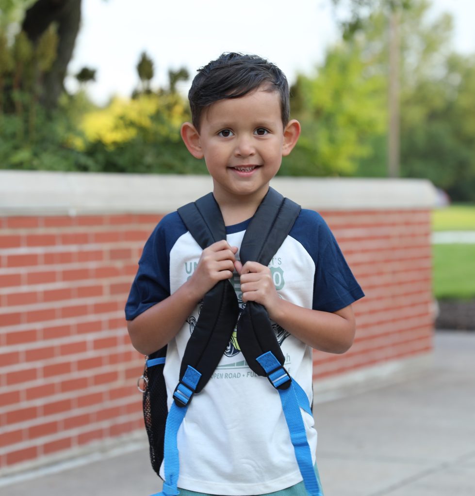 Young male elementary student with backpack