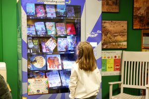 student looking at book vending machine