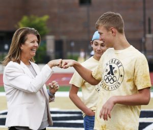 Superintendent Dr. Heather Short fists bumps a student
