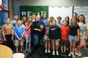 A group of people posing for a picture in front of a classroom.