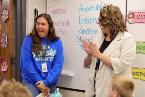 Principal Lindsay Helman-Cass claps and congratulates Josie Engdahl after surprising her with the news that she's PHM's 2026 Elementary Teacher of the Year