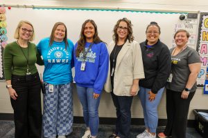 Josie Engdahl with Principal Lindsay Helman-Cass and her fellow Meadow's Edge educators