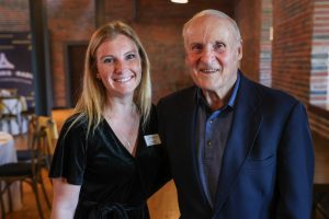 An older man and a woman posing for a picture in a restaurant.
