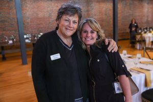 Two women posing for a picture at an event.
