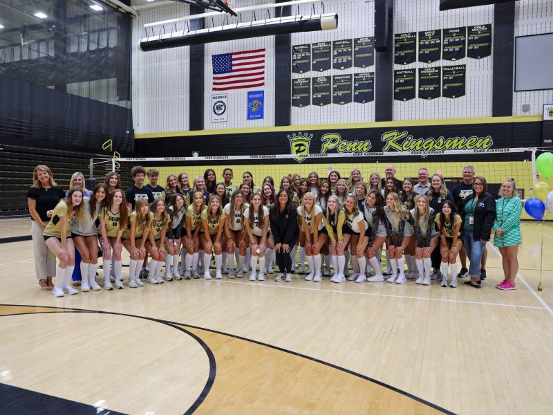 A group of cheerleaders posing for a picture on a basketball court.