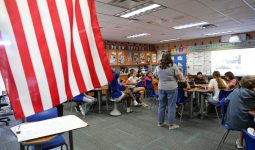 The room is decorated with two large american flags.